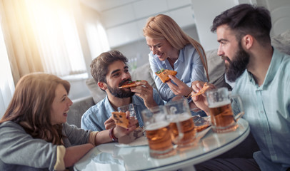 Group of friends taking their slices of pizza