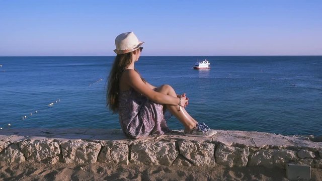 girl on the coast looking to azure sea