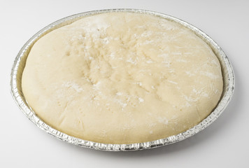 Raw pizza dough in its mold ready to bake