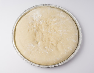 Raw pizza dough in its mold ready to bake