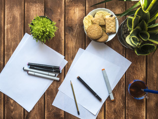 drawing markers on white paper on a wooden table