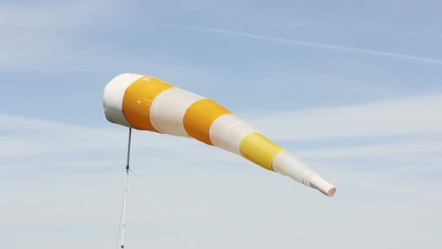 Windscreen at the airport against the blue sky. Weather vane moves in the wind