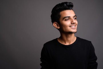 Fototapeta premium Young Indian man against gray background