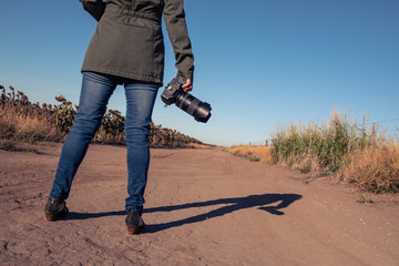 Woman holding an SLR camera from behind
