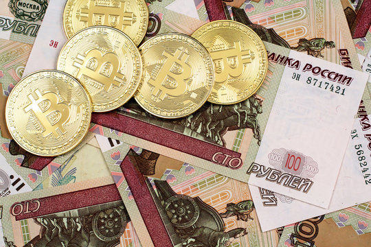 A close up image of Russian currency with gold Bitcoins