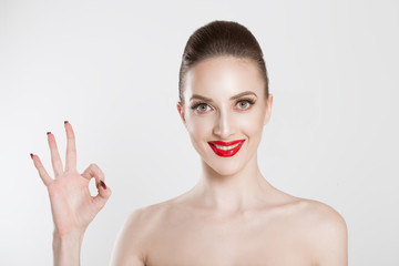 Happy bride. Portrait beautiful happy young woman showing Ok sign with hand isolated on light blue...