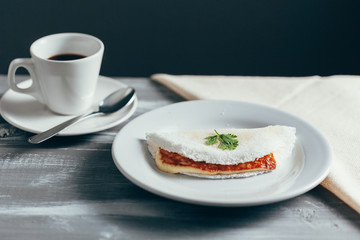 Brazilian Tapioca with cheese (coalho) and coffee over a wooden table