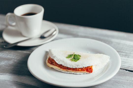 Brazilian Tapioca with cheese (coalho) and coffee over a wooden table