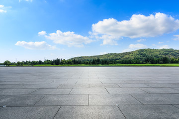 Empty square floor and hills with sky clouds
