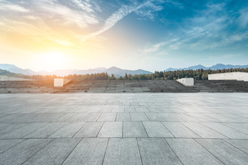 Empty square floor and hills landscape at sunset