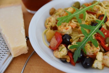 Nudeln, Shrimps, Oliven, Paprika - garniert mit Rucola