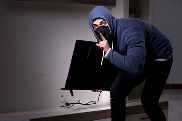 Burglar thief stealing tv from apartment house