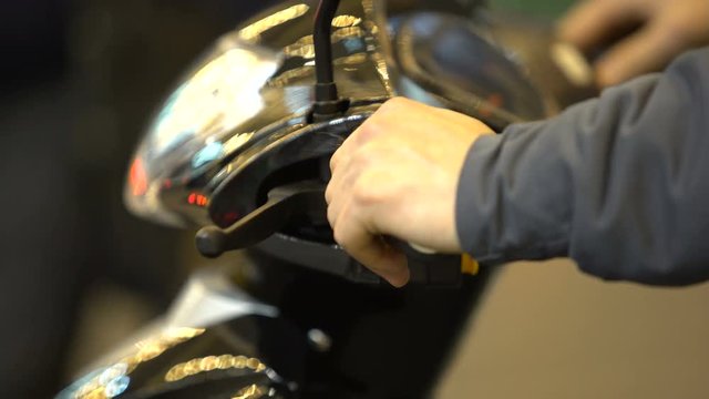Male buyer testing motorbike in salon, transport store customer choosing moped