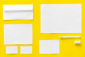 Blank stationery for branding, envelopes on yellow background top view mockup pattern