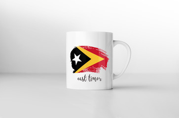 East Timor flag souvenir mug on white background. 3D rendering.