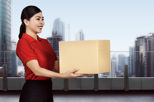 Young asian delivery woman carrying the package