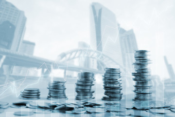 Double exposure of city and rows of coins for finance and business concept