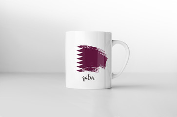 Qatar flag souvenir mug on white background. 3D rendering.