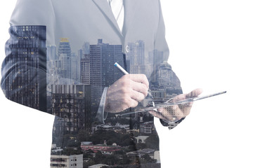 Double exposure of success businessman using digital tablet with city landscape background
