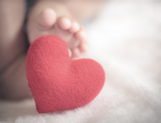 baby's feet with a red heart in vintage tone style