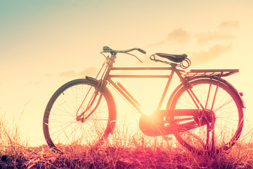 Naklejka na ściany i meble beautiful landscape image with Bicycle at sunset in vintage tone style