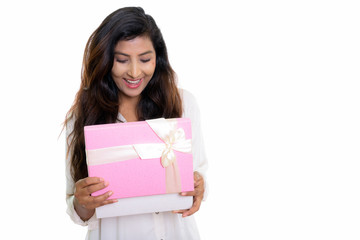 Studio shot of young happy Persian woman smiling while opening g