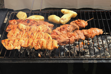 Skewers with meat and potatoes on the grill