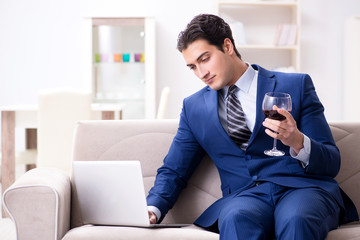 Businessman drinking wine sitting at home