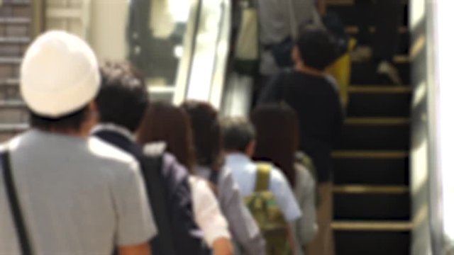 SHINJUKU,  TOKYO,  JAPAN - CIRCA MAY 2018 : BACK SHOT of PEOPLE using ESCALATOR near Shinjuku train station.