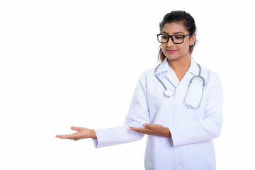 Studio shot of young beautiful Persian woman doctor showing some