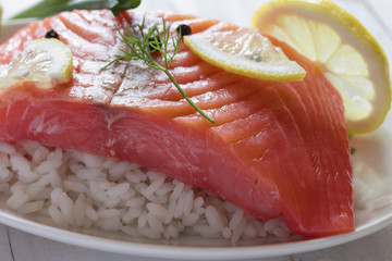 a large piece of meaty salmon with rice and lemon