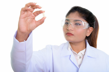 Close up of young fat Persian woman doctor looking at vitamin ta