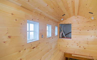 Empty room in a new wooden house under construction of wooden walls