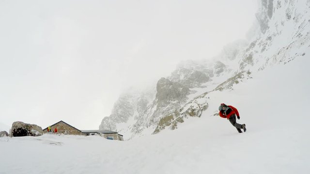 4K footage of a man going up the snowy mountain