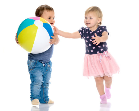 Toddler boy and girl playing with ball.
