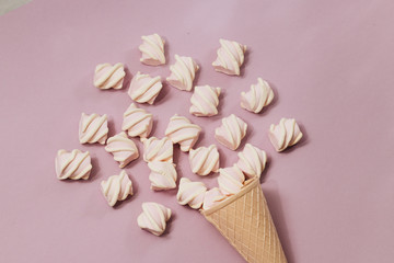 Flat lay of delicious sweet marshmallows and colorful macaroons on lilac background