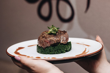 Woman holding plate with delicious roasted meat