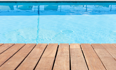 Fototapeta na wymiar piscine bleue avec plage bois