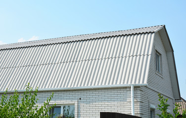Brick house with asbestos white roof and white brick wall for energy efficiency with cooling.