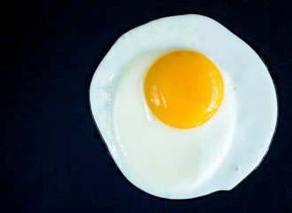 Fried egg isolated on black background