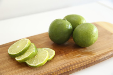 Detail of fresh green limes on a wooden board