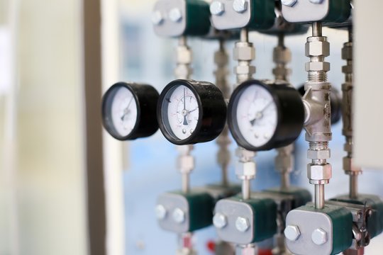 Closeup meter and valves on pipes in laboratory.