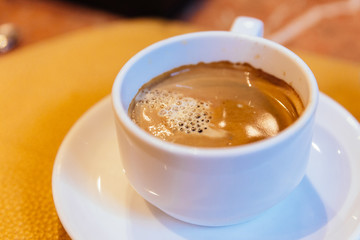 Black coffee in white cup served after the meal.