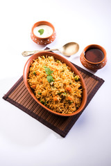 Indian Vegetable Pulav or Biryani made using Basmati Rice, served in terracotta bowl. selective focus