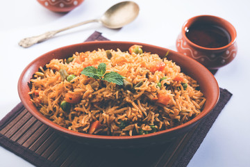 Indian Vegetable Pulav or Biryani made using Basmati Rice, served in terracotta bowl. selective focus