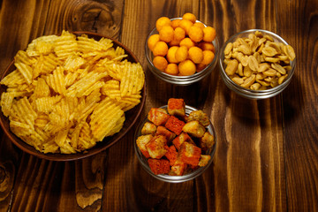 Mix of snacks for beer on wooden table