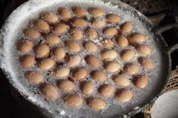 Eggs boiled in a beautiful saline in a black pan.