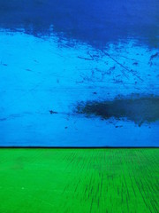 blue paint on smooth metal with scuffs and green wood fragment similar to the sky and meadow