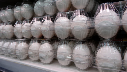 Fototapeta na wymiar Eggs in transparent containers on the chilled shelf at grocery store