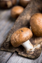 Fresh mushrooms on the rustic wooden background. Selective focus. Shallow depth of field.